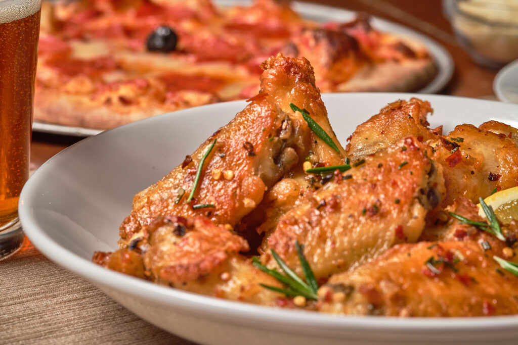 A bowl of Tuscan CHicken Wings, spicy wings marinated in lemon & rosemary